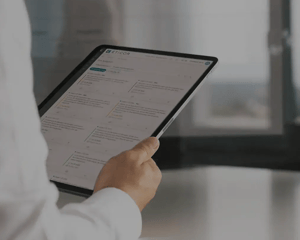 Person hält Tablet mit geöffneter Eticor Compliance Management Software.